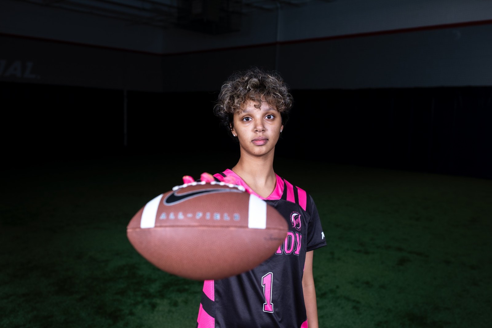 Minnesota Motion athlete holding a football toward the camera